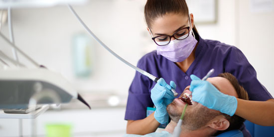 Eine Zahnäztin behandelt einen Patienten